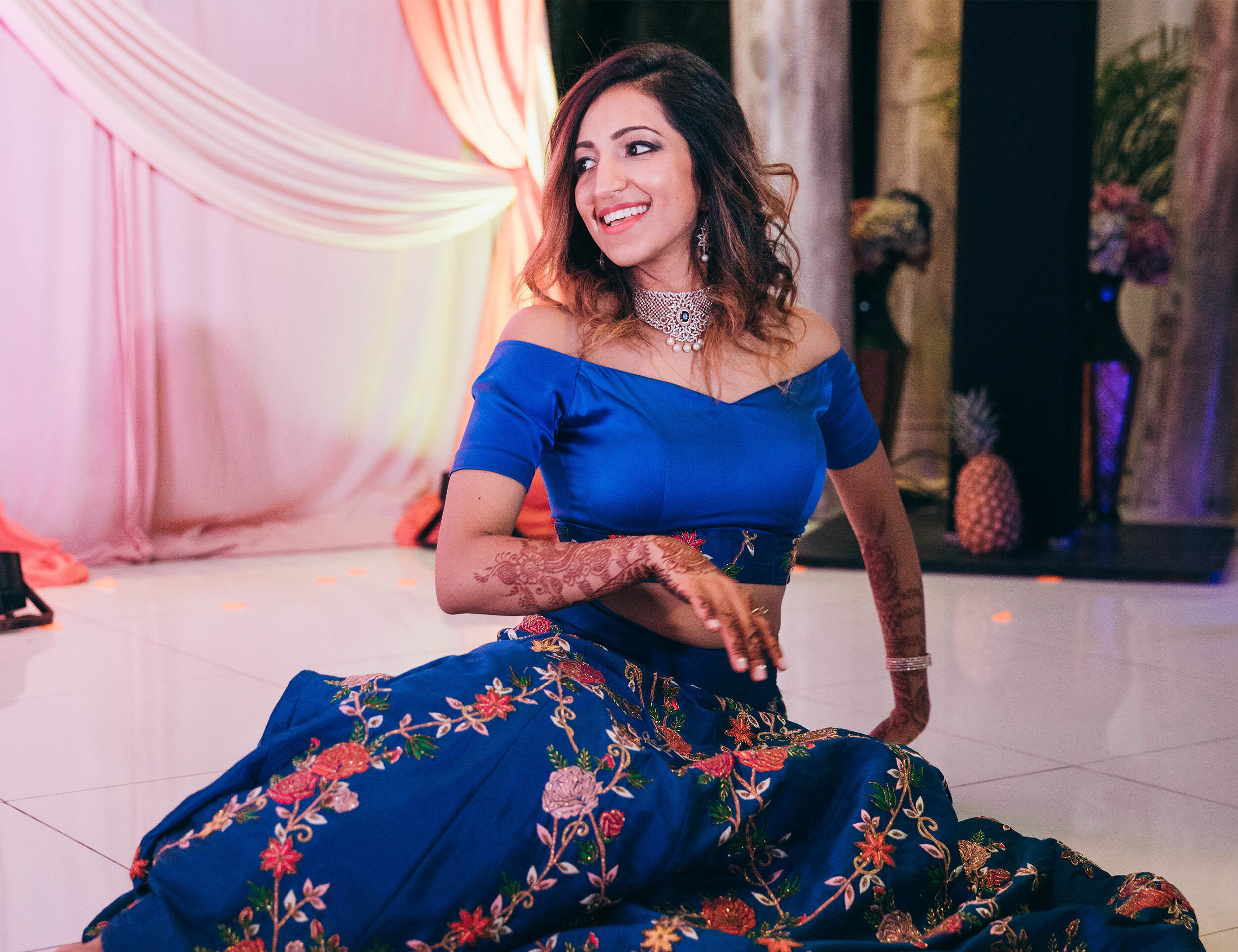 Girl showing intricate Mehendi design during a wedding celebration